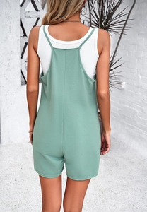 Back view of mint green casual overalls with adjustable straps on a female model