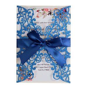 Elegant laser cut navy blue glitter wedding invitation set with a matching satin ribbon bow