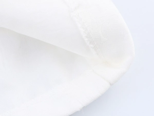 Dettaglio macro del tessuto bianco e cuciture di precisione sull'orlo del blazer