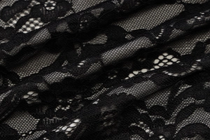 Close-up of black lace mesh fabric featuring exquisite floral embroidery and texture