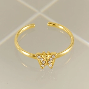 Macro shot of gold butterfly open ring with sparkling cubic zirconia on gray tile