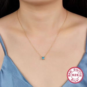 S925 sterling silver gold necklace with square blue zircon pendant worn on model's neck