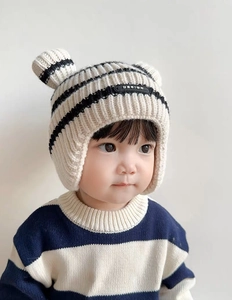 Detail of baby striped knit hat with ear flaps and cute decorative 3D ears