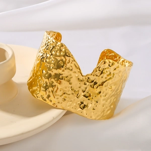 French retro gold-colored V-shape pleated wide open cuff bracelet on white silk fabric