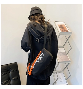 Détail de la bandoulière en nylon avec chaîne orange et imprimé sport sur mannequin