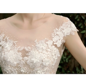 Macro view of exquisite lace appliques and beadwork on the ivory wedding dress bodice