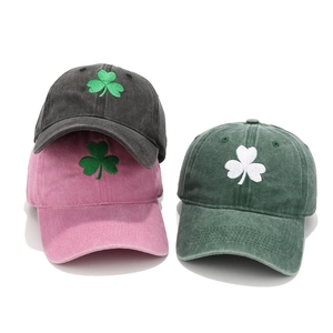 Detailed view of three washed cotton baseball caps showing green and white shamrock embroidery