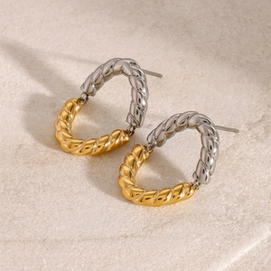 Macro detail of twisted rope hoop earrings in two-tone gold and silver polished finish