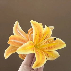 Detailed close-up of a realistic yellow lily hair claw clip with vibrant red spots