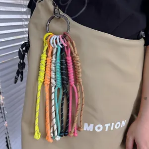 Close-up of vibrant woven rope keychains in 7 colors attached to a khaki handbag