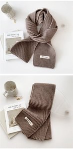 Detailed texture of brown knitted winter scarf with brand tag and aesthetic lifestyle props