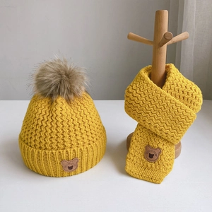 Kids warm knit hat and scarf set in bright yellow with cute bear patch and faux fur pom