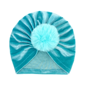 Close-up of baby velvet beanie featuring a soft faux fur pompom and tie-dye texture