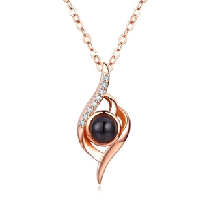 Macro shot of rose gold necklace featuring small pavé zircons and a black projection stone