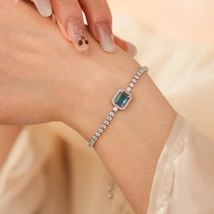 Macro view of adjustable silver bracelet with square blue zircon and pavé chain