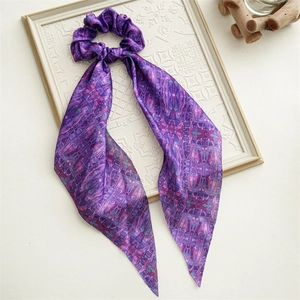 Close-up of periwinkle blue floral satin scrunchie with ribbons on vintage frame