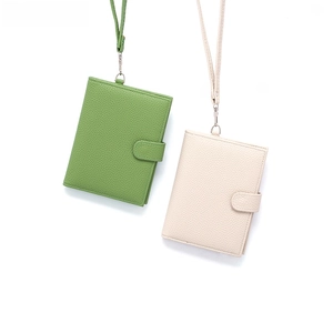 Detail view of leather passport holders with lychee texture, snap closure and lanyards