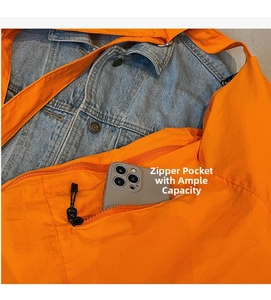 Detail of the orange nylon crossbody bag showing the zipper pocket and internal storage space