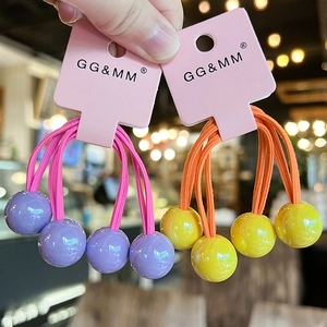 Detailed view of elastic hair ties with purple and yellow oversized candy beads