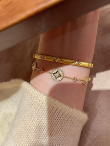 Close-up of 18K gold plated starburst cuff bracelet and dainty compass star chain jewelry