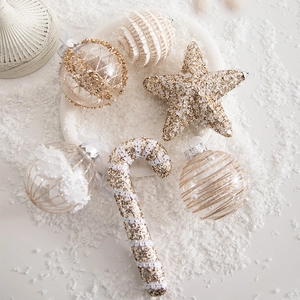 European Christmas ornaments set with gold glitter stars and white beads on faux snow