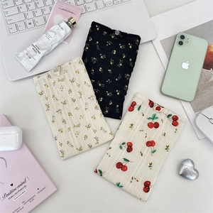 Détail de pochettes de téléphone en mousseline fleurie avec texture plissée et bouton
