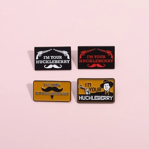 Detail showing four I'm Your Huckleberry enamel pins with various font and color designs