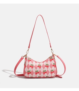 Détail du motif cerise rose et de la texture matelassée sur sac en cuir PU