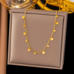 Minimalistische goldene Titanstahlkette mit runden Anhängern auf einer Schmuckschatulle