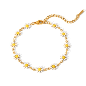 Detailaufnahme des goldenen Emaille-Gänseblümchen-Armbands mit weißen Blumenanhängern