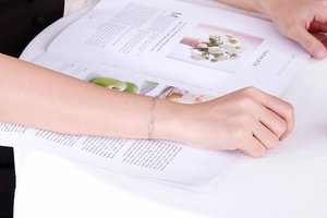 Close-up of minimalist silver titanium steel chain bracelet worn on a female wrist
