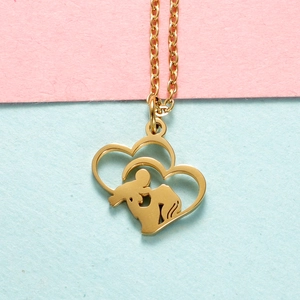 Golden stainless steel heart necklace with mother and child embrace pendant on soft background