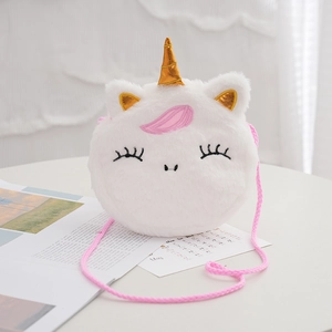 Cute unicorn plush crossbody bag for kids with gold horn and pink rope strap on desk