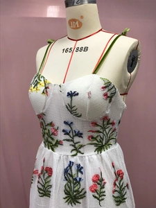 Nahaufnahme der bunten Blumenstickerei und Cup-Details am weißen Netzkleid