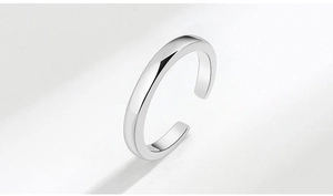 Detailed macro shot of a polished silver spinning snowflake ring on a white background