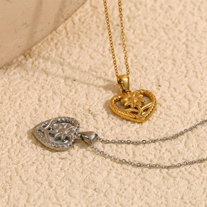 Détail des pendentifs fleur en nacre et cœur en acier inoxydable doré et argenté