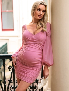 Dettaglio dell'abito premaman rosa con maniche lunghe in mesh e design a pieghe a V