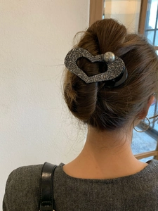 Dettaglio della molletta a cuore con glitter grigio scuro e perla d'argento