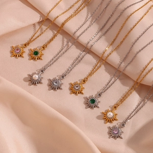 Detail view of 18K gold plated stainless steel necklaces with zircon star pendants on silk