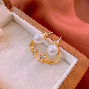 Elegant gold pearl earrings with sparkling crystals displayed in a luxury jewelry box