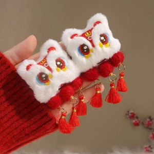 Close-up of Chinese New Year lion dance hair clips with plush texture and red tassels