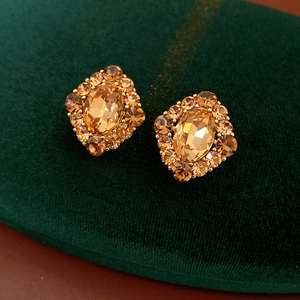 Détail macro de boucles d'oreilles vintage en cristal doré sur velours vert