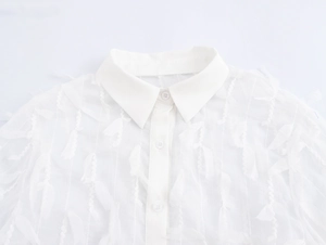 Detail of white shirt collar featuring elegant lapels and textured feather-like fabric