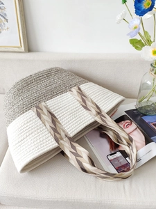 Bohemian woven cotton tote bag with geometric straps on a minimalist sofa