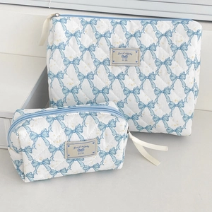 Quilted makeup bag set with light blue bow floral print and zip closure in cream white