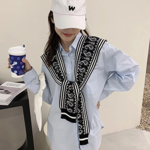 Knit shawl scarf with black and white stripes draped over a blue shirt for women