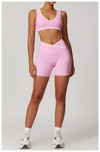 Detail of light pink yoga set with white contrast trim and crossover high waist shorts