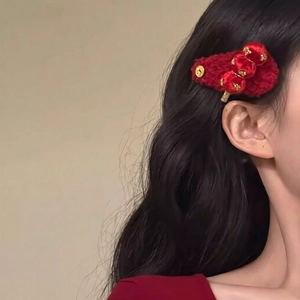 Close-up of red knitted hair clip with velvet plush balls on a model side view
