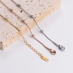 Three-color round bead snake chains in gold, rose gold, and silver on natural stone base