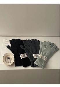Three pairs of wool knit gloves in black, dark grey, and light green with sewn-on tags